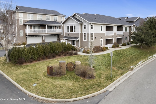 view of front facade featuring a garage, a balcony, and a front lawn