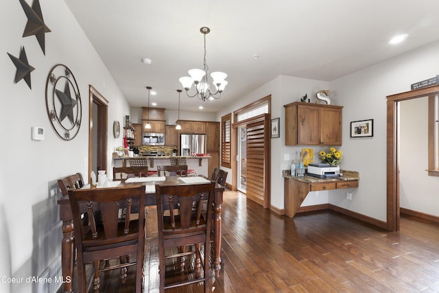 dining space with dark hardwood / wood-style floors and a notable chandelier