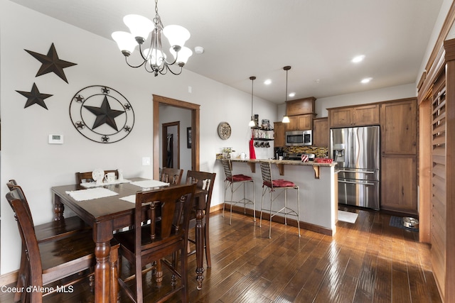 dining space with dark wood-type flooring and a chandelier