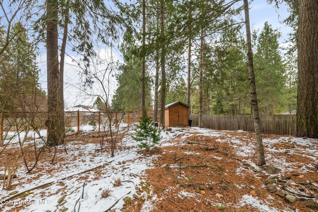 yard covered in snow featuring a storage unit