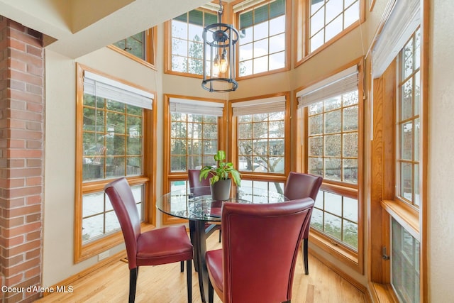 dining area with a high ceiling and light wood-type flooring