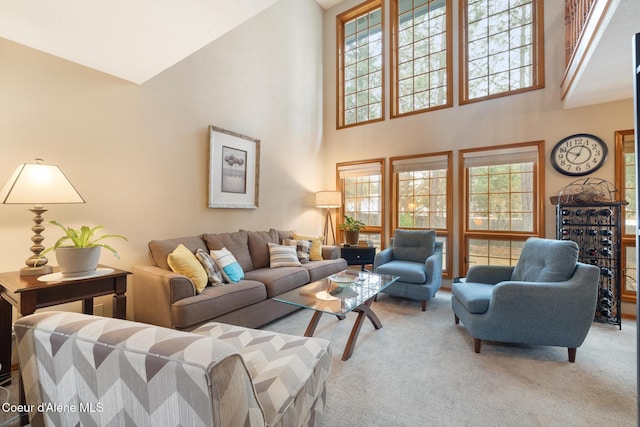 living room with light colored carpet, a healthy amount of sunlight, and a towering ceiling