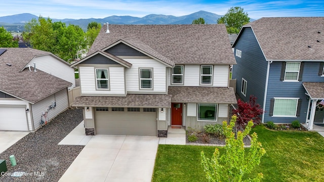 view of front of property with a garage, a mountain view, and a front yard