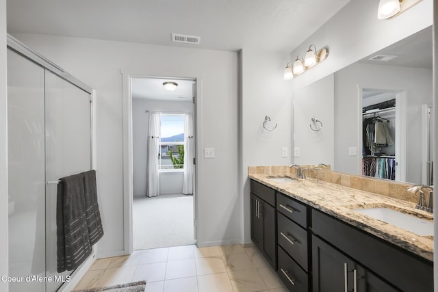 bathroom with vanity, tile patterned floors, and a shower with door