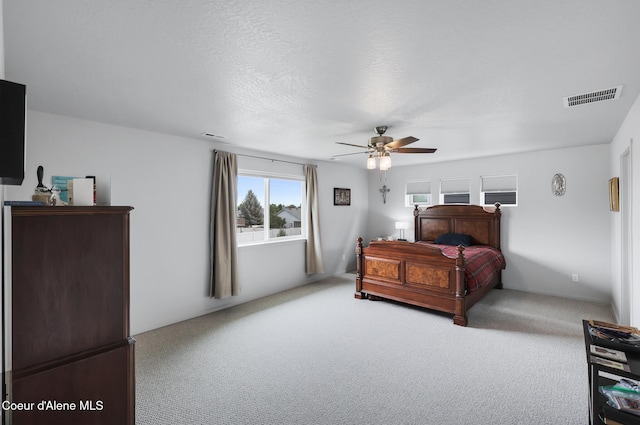 carpeted bedroom with a textured ceiling and ceiling fan