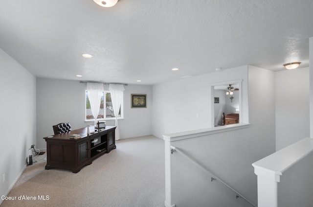 carpeted office space featuring a textured ceiling