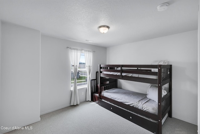 bedroom with carpet floors and a textured ceiling