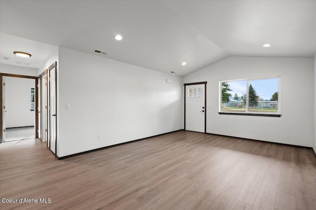 unfurnished room with lofted ceiling and light hardwood / wood-style floors