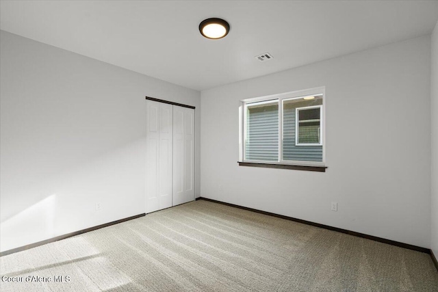 unfurnished bedroom featuring carpet and a closet