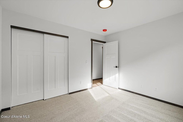 unfurnished bedroom featuring light colored carpet and a closet