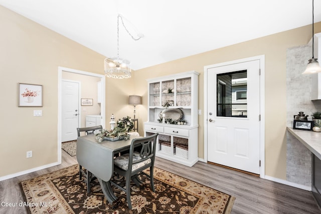 dining space featuring lofted ceiling, hardwood / wood-style floors, and a chandelier