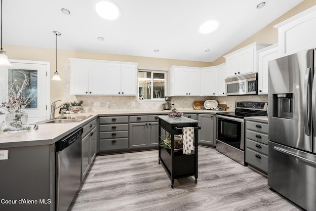 kitchen with gray cabinets, appliances with stainless steel finishes, pendant lighting, tasteful backsplash, and sink