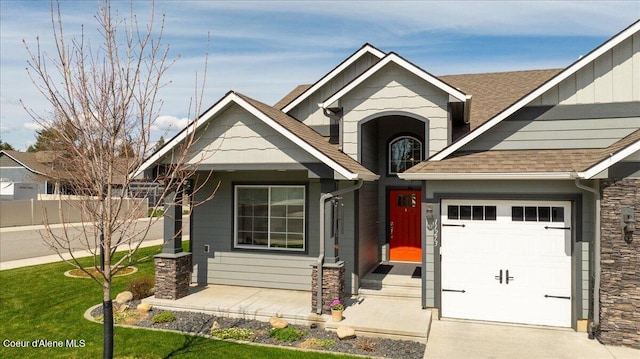 craftsman-style house featuring a garage and a front lawn