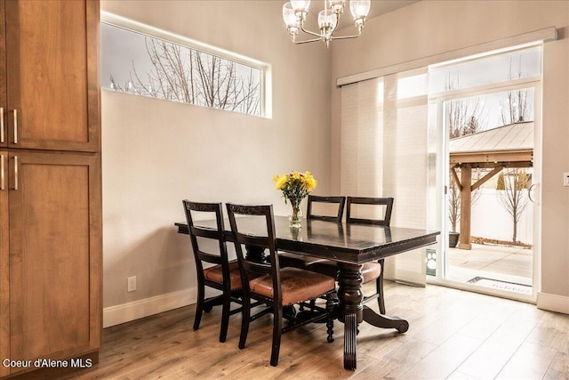 dining space with an inviting chandelier and light hardwood / wood-style floors