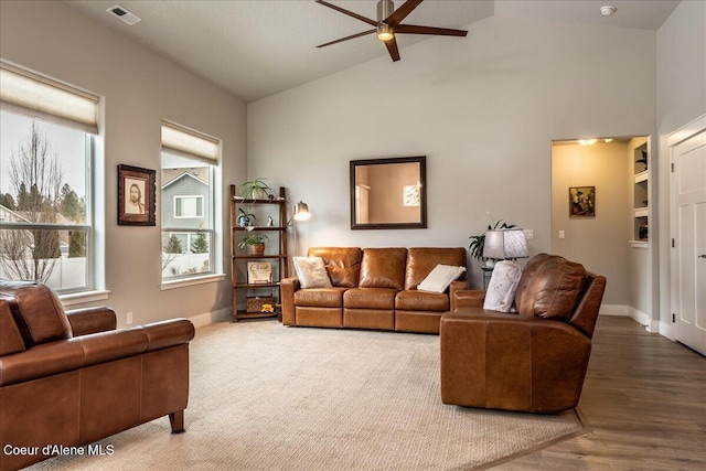 living room featuring wood-type flooring, lofted ceiling, and ceiling fan