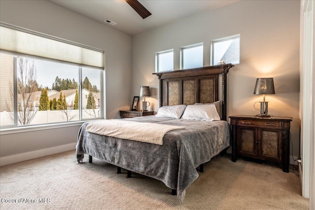 carpeted bedroom featuring multiple windows and ceiling fan