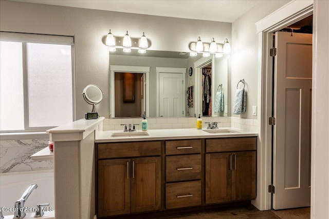 bathroom with tasteful backsplash, vanity, a washtub, and hardwood / wood-style flooring