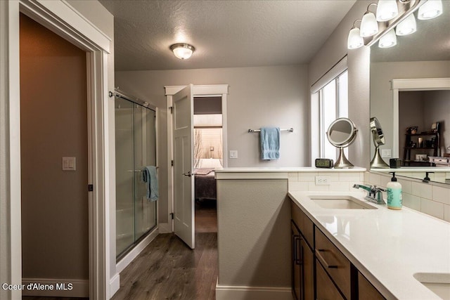 bathroom with vanity, wood-type flooring, a textured ceiling, and walk in shower