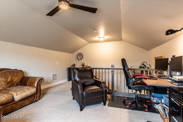 home office featuring ceiling fan, lofted ceiling, light carpet, and a textured ceiling