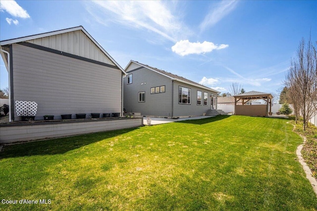 rear view of house with a yard and a gazebo