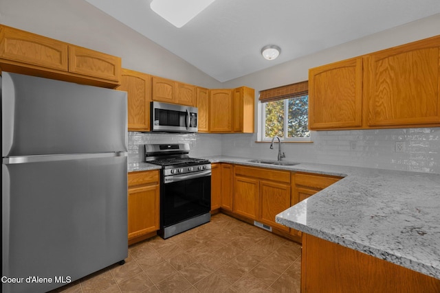 kitchen featuring lofted ceiling, sink, light stone counters, tasteful backsplash, and stainless steel appliances