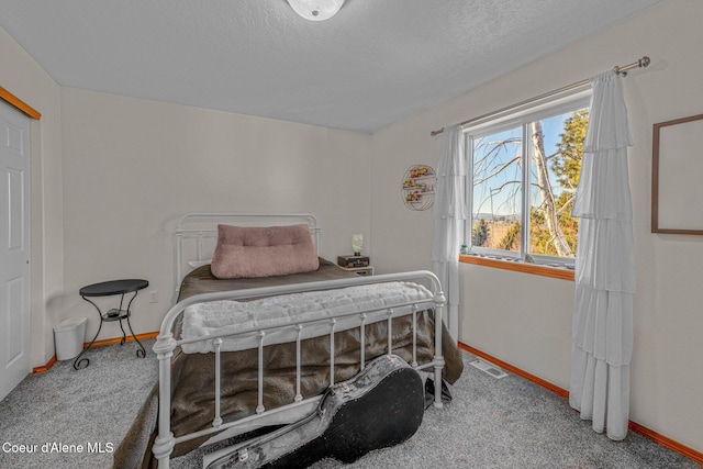 carpeted bedroom featuring a textured ceiling