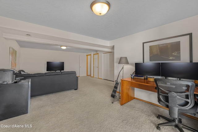 office area featuring light carpet and a textured ceiling