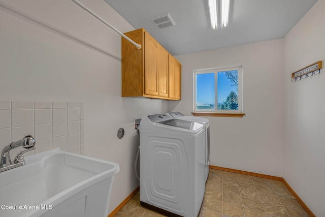 washroom featuring cabinets, sink, and washing machine and dryer