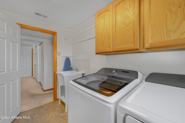 laundry area with cabinets, separate washer and dryer, and light carpet