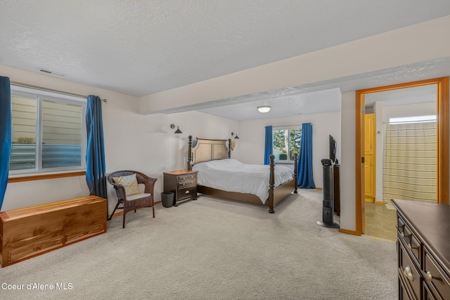 bedroom with light carpet and a textured ceiling