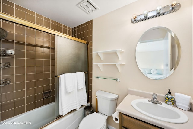 full bathroom with vanity, bath / shower combo with glass door, and toilet