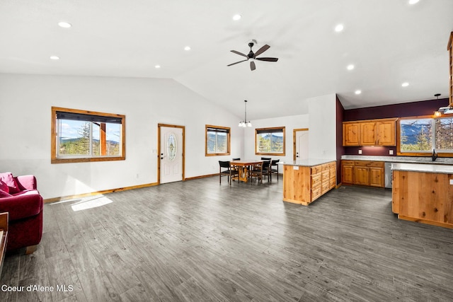 kitchen with open floor plan, dark wood finished floors, a peninsula, light countertops, and vaulted ceiling