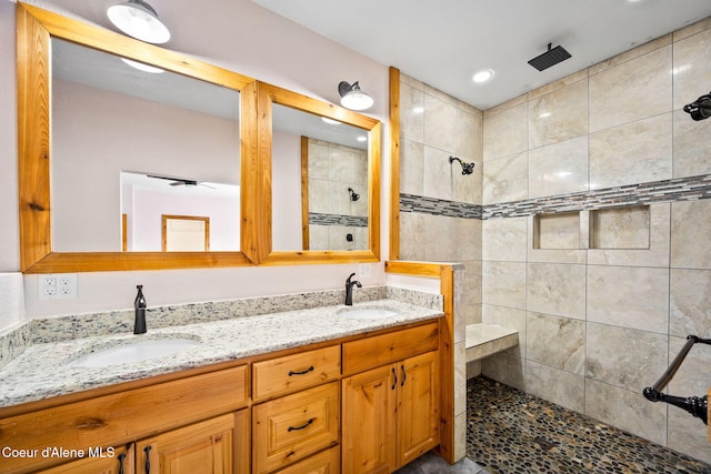 bathroom with double vanity, a walk in shower, and a sink