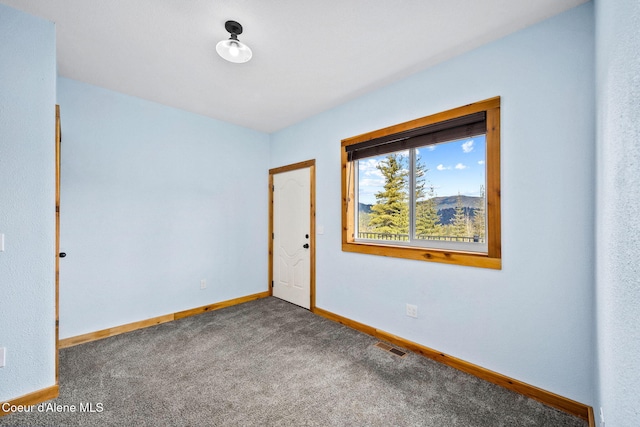 carpeted empty room with visible vents and baseboards