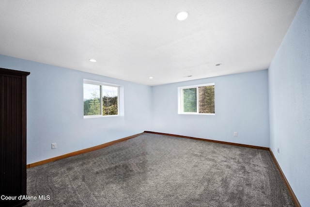 carpeted empty room featuring recessed lighting and baseboards