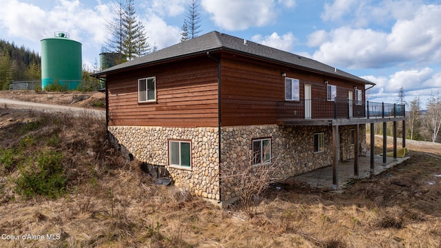 view of home's exterior with stone siding and a patio