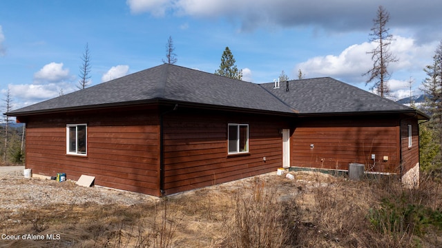 view of home's exterior featuring central air condition unit and roof with shingles