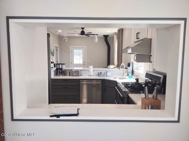 kitchen with appliances with stainless steel finishes, sink, white cabinets, and ceiling fan