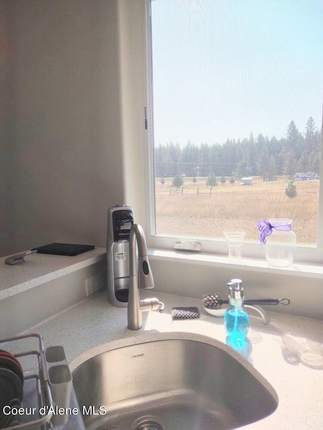 room details featuring light stone countertops and sink