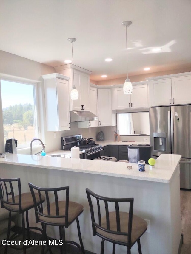 kitchen with hanging light fixtures, white cabinetry, and kitchen peninsula