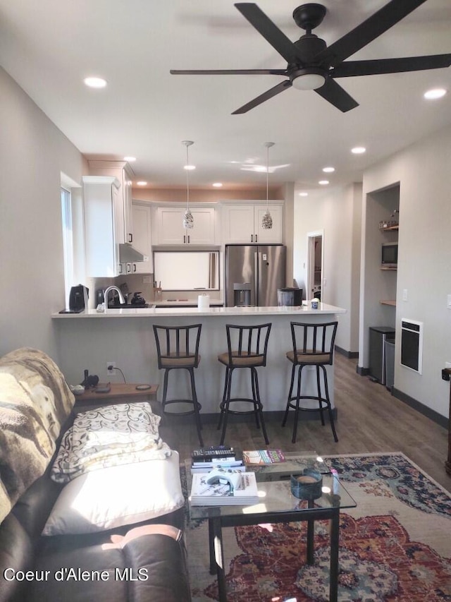 living room featuring dark wood-type flooring, ceiling fan, and sink