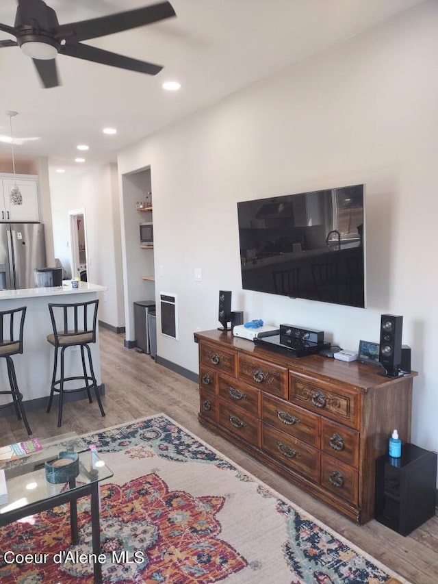 living room featuring ceiling fan and light hardwood / wood-style flooring