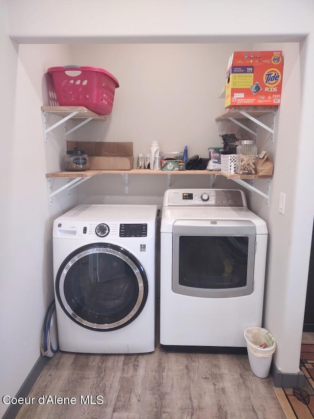 laundry area featuring light hardwood / wood-style flooring and washing machine and clothes dryer