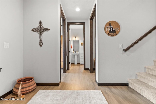 hallway with sink and light hardwood / wood-style floors