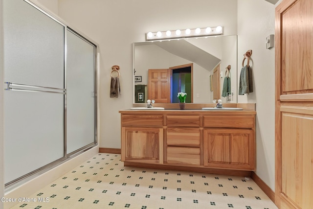 bathroom featuring a shower with door and vanity