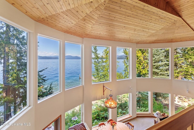 unfurnished sunroom with a water view and wooden ceiling