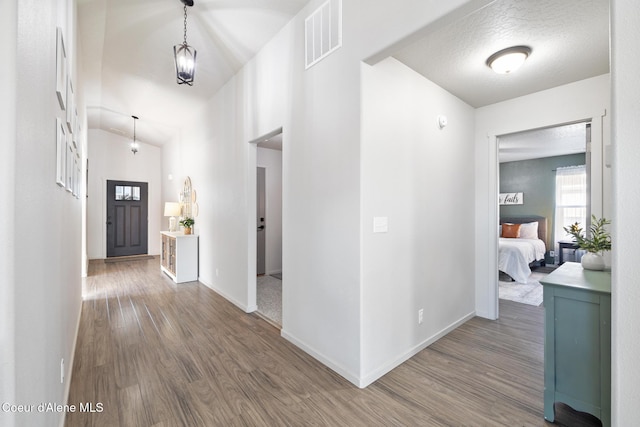 corridor with hardwood / wood-style flooring and a textured ceiling