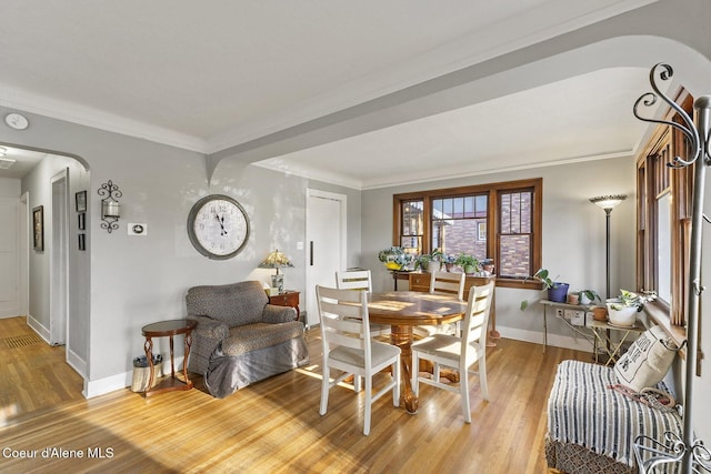 dining room featuring crown molding and light hardwood / wood-style flooring