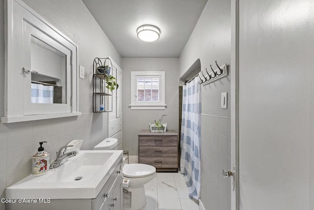 bathroom with tile walls, vanity, toilet, and walk in shower