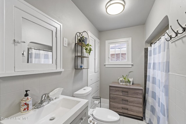 bathroom featuring tile walls, vanity, curtained shower, and toilet